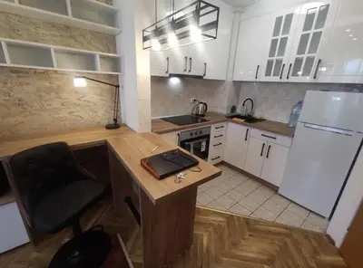 a kitchen with a desk and a white refrigerator at Apartman Osmeha in Mladenovac