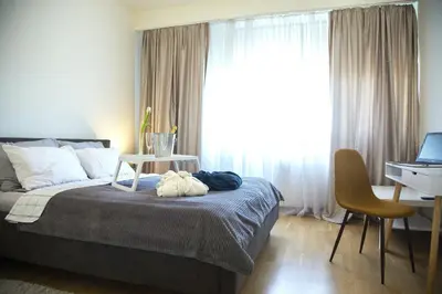 a bedroom with a bed with a desk and a window at Apartment BW Maria Belgrade in Sajmište