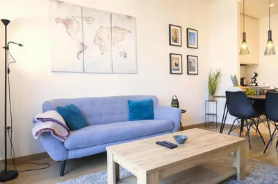 a living room with a blue couch and a table at Apartment BW Maria Belgrade in Sajmište