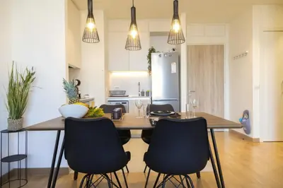 a kitchen and dining room with a wooden table and chairs at Apartment BW Maria Belgrade in Sajmište