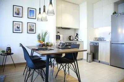 a kitchen with a table and some chairs and a refrigerator at Apartment BW Maria Belgrade in Sajmište