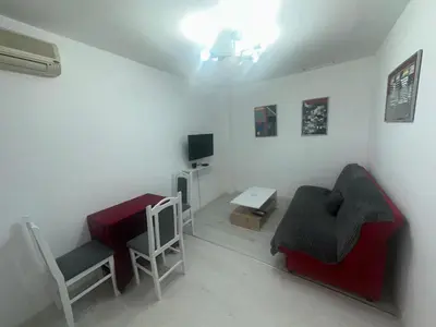a living room with a red couch and a table at STAN Beograd in Belgrade