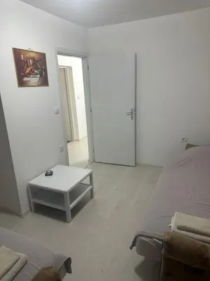 a white room with a bed and a table at STAN Beograd in Belgrade