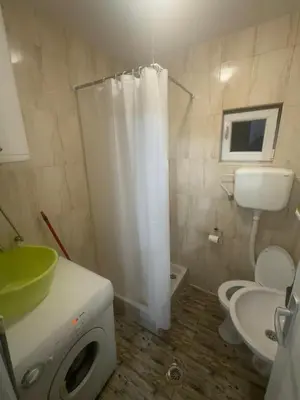 a bathroom with a white shower curtain and a toilet at STAN Beograd in Belgrade