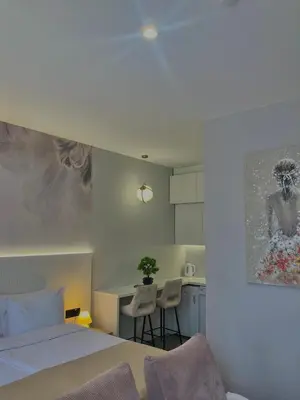 a bedroom with a bed and a kitchen with a table at Move In Apartments - ApartHotel Belgrade in Belgrade