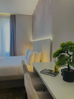a hotel room with a bed and a table with a potted plant at Move In Apartments - ApartHotel Belgrade in Belgrade