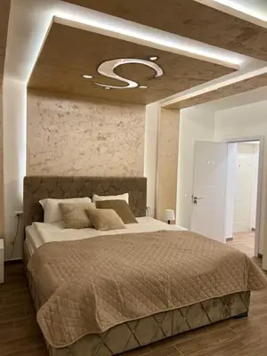 a bedroom with a large bed in a room with a ceiling at 5 star apartment in Novi Grad