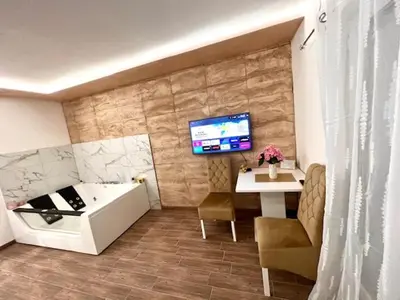 a bathroom with a tub and a table and a tv at 5 star apartment in Novi Grad