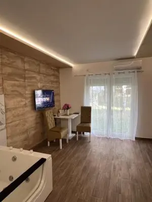 a living room with a table and a tv on a wall at 5 star apartment in Novi Grad