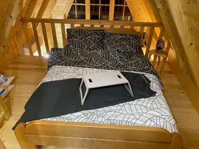 a wooden bed with a black and white comforter and a white at Danube Oasis Stevantown 3 in Stari Banovci