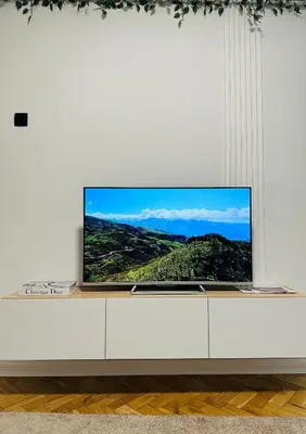 a flat screen tv sitting on top of a white cabinet at Banovo Brdo Premium in Čukarica