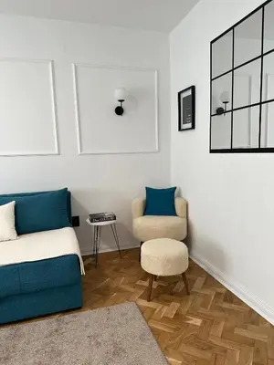 a living room with a bed and a chair at Banovo Brdo Premium in Čukarica