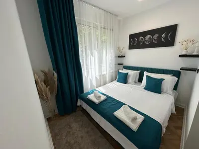 a bedroom with a bed with blue and white pillows at Banovo Brdo Premium in Čukarica
