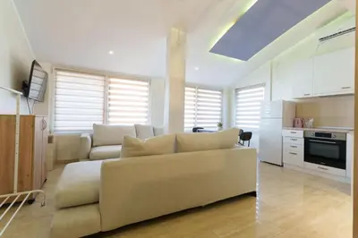 a living room with a couch and a kitchen at Step rooms apt spa in Belgrade