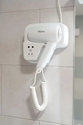 a white hairdryer hanging on a wall at Step rooms apt spa in Belgrade