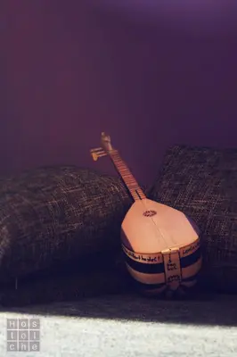 a wooden acoustic guitar sitting on a couch at HostelChe Hostel in Belgrade
