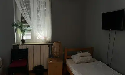 a small bedroom with a bed and a window at HostelChe Hostel in Belgrade
