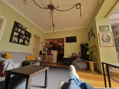 a living room with a person laying on a couch at HostelChe Hostel in Belgrade