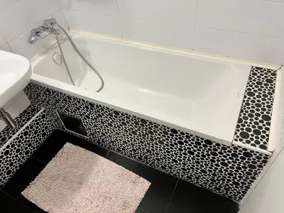 a bath tub with a black and white tile floor at Waterfront with free parking in Sajmište