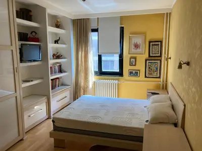 a bedroom with a bed and a tv and shelves at Waterfront with free parking in Sajmište
