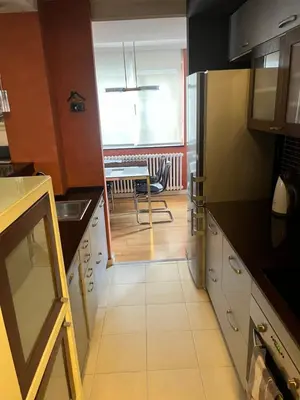 a kitchen with black counters and white cabinets at Waterfront with free parking in Sajmište