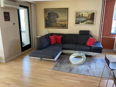 a living room with a blue couch and red pillows at Waterfront with free parking in Sajmište