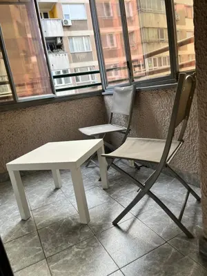 a white table and a chair in front of a window at Waterfront with free parking in Sajmište