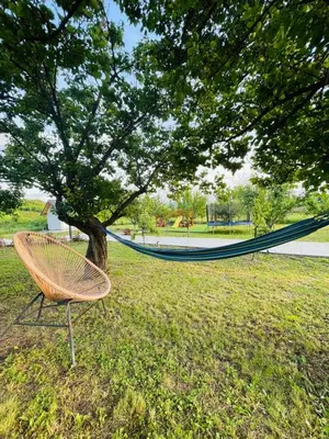 a hammock sitting under a tree in a park at Panorama Kosmaj in Sopot