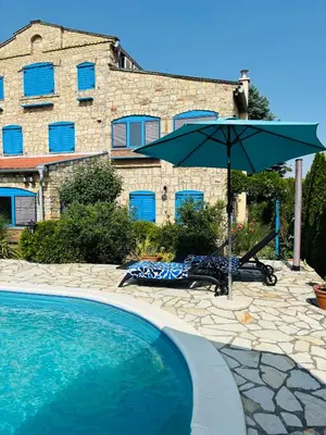 a pool with a table and an umbrella at Stone villa in Fruška gora in Irig
