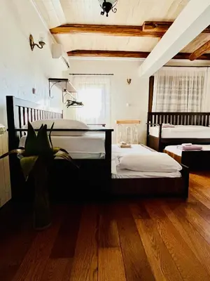 two beds in a room with wooden floors at Stone villa in Fruška gora in Irig