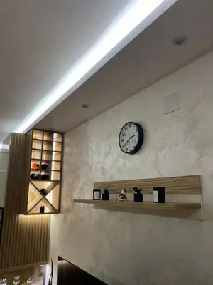 a clock on the wall of a room with shelves at Apartmani Kolaković in Arandjelovac