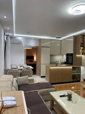 a living room with a couch and a kitchen at Apartmani Kolaković in Arandjelovac