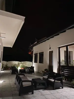 a patio with chairs and tables at night at Apartmani Kolaković in Arandjelovac