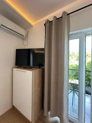 a living room with a television and a curtain at Apartman Igor in Surčin