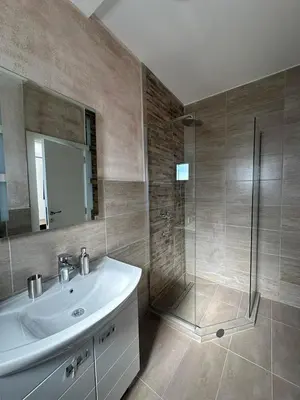 a bathroom with a sink and a glass shower at Apartman Igor in Surčin