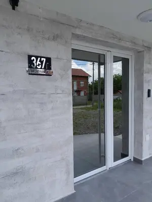 a sign on the side of a building with a sliding glass door at Apartman Igor in Surčin