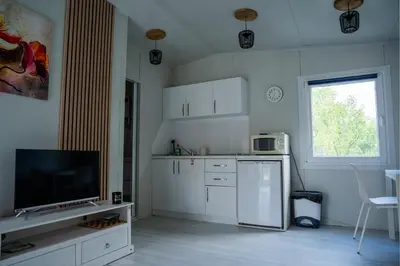 a kitchen with white cabinets and a flat screen tv at Seosko turističko domaćinstvo Tisa i Begej in Kni°anin