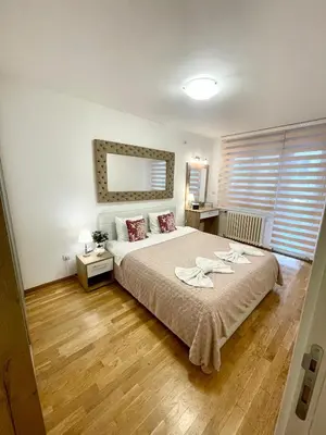 a bedroom with a large bed with two towels on it at Tiara Vracar Apartment in Belgrade