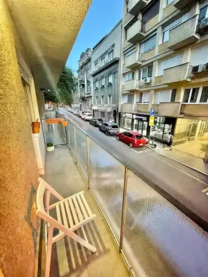 a balcony with a chair on a city street at Tiara Vracar Apartment in Belgrade
