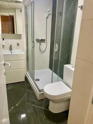 a bathroom with a shower and a toilet and a sink at Tiara Vracar Apartment in Belgrade