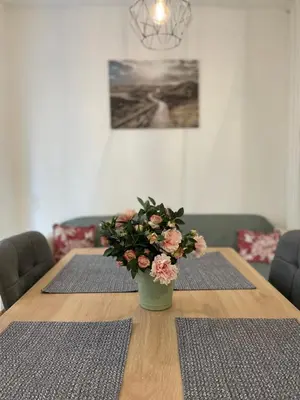a wooden table with a vase of flowers on it at Tiara Vracar Apartment in Belgrade