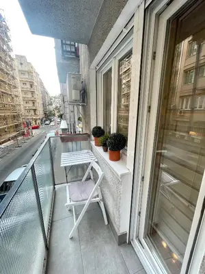 a white chair sitting on the balcony of a building at Tiara Vracar Apartment in Belgrade