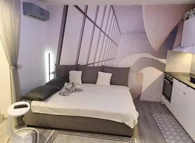a bedroom with a bed with a dog sitting on it at Studio Lara in Voždovac