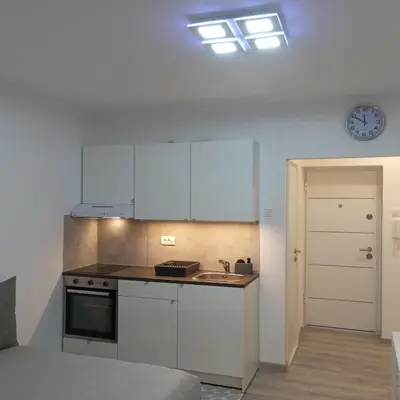 a kitchen with white cabinets and a counter top at Studio Lara in Voždovac