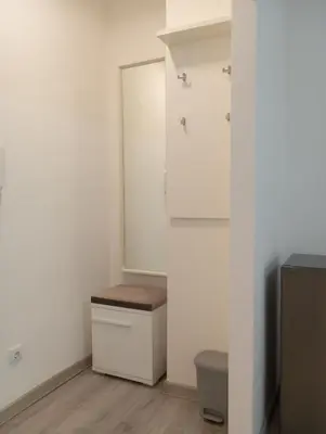 a bathroom with white walls and a toilet and a door at Studio Lara in Voždovac
