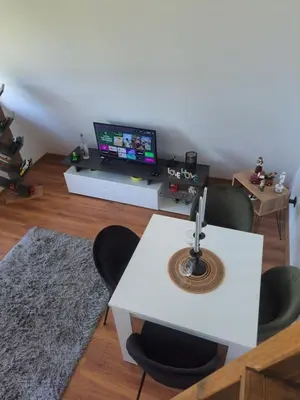 a living room with a tv and a table and chairs at Vikendica na Avali in Donja Ralja