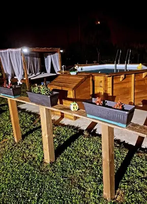 a picnic table with three plants on it with a pool at Vikendica na Avali in Donja Ralja
