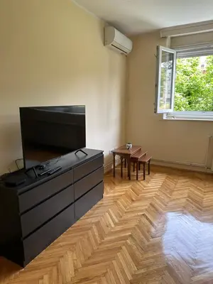 a living room with a large television and a table at petrov apartman in Belgrade