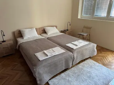 two beds in a bedroom with towels on them at petrov apartman in Belgrade