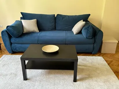 a blue couch with a coffee table in a living room at petrov apartman in Belgrade